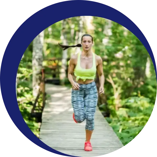 A woman running on a bridge in the woods.